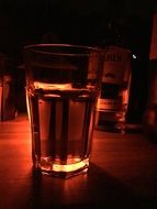 glasses with drink in dark red lighting