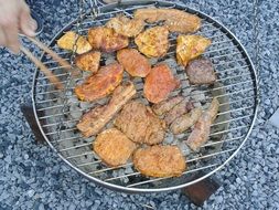 person grilling meat, barbecue