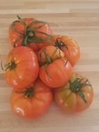 fresh red tomatoes on a wooden surface