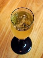 a glass of white champagne on a wooden table