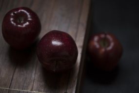 Dark Red apples on wooden table macro fresh