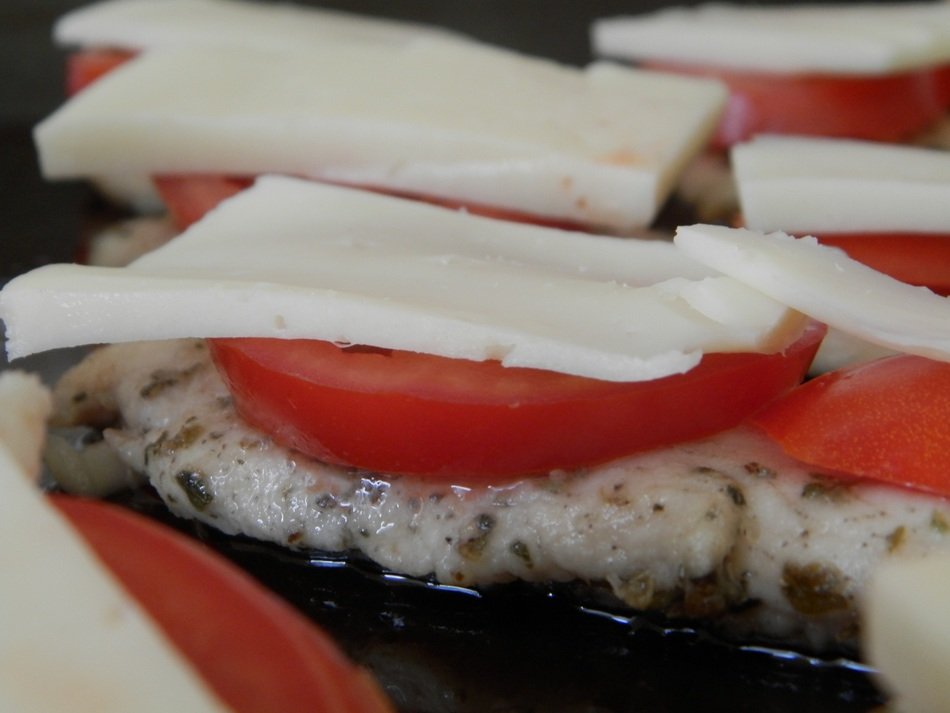 cheese and tomatoes on meat cooking