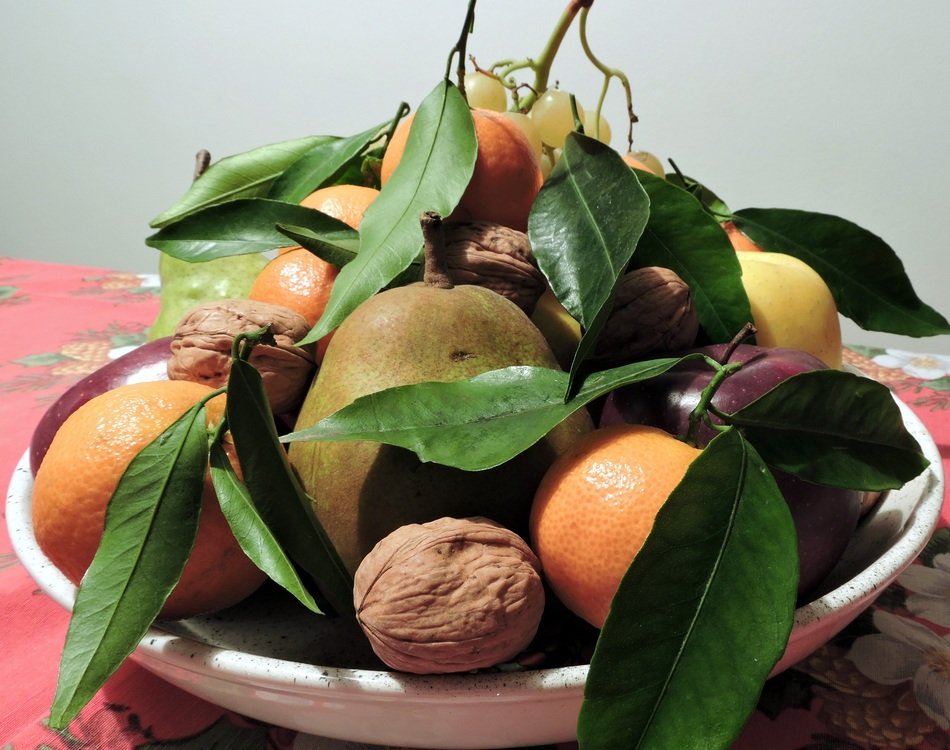 apple, orange, tangerine, grapes and walnut on a tray