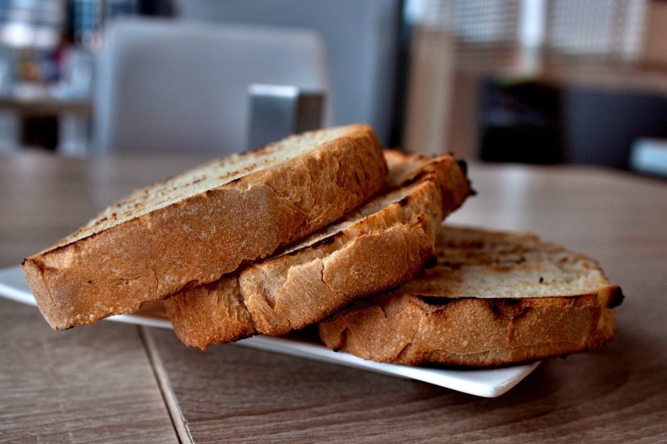 Roasted bread on the plate on a table on a blurred background