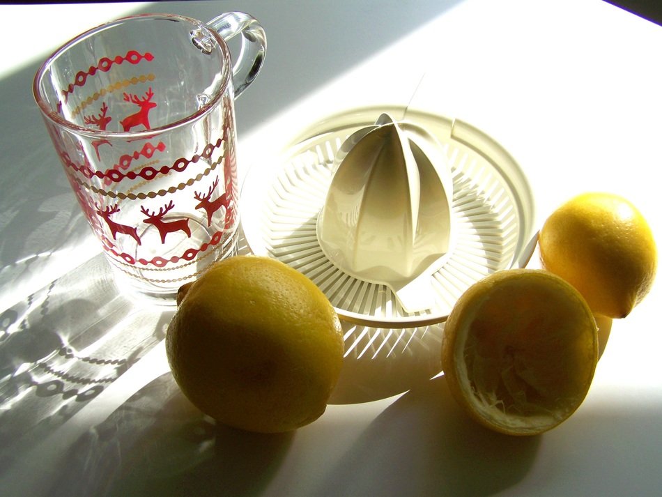 lemon, measuring cup and juice extractor