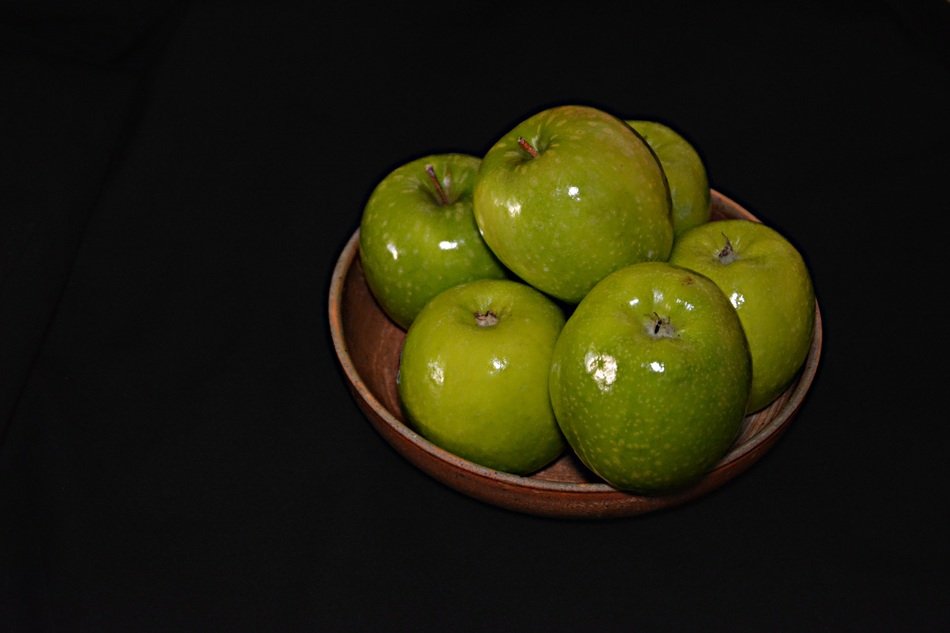 Green apples in brown dish