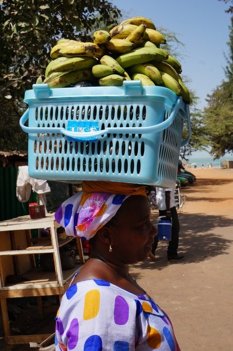 bananas in a basket on a woman's head