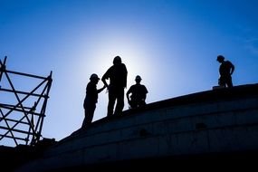 worker's silhouettes on the roof