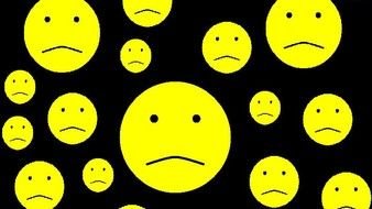 Sad smileys at black background