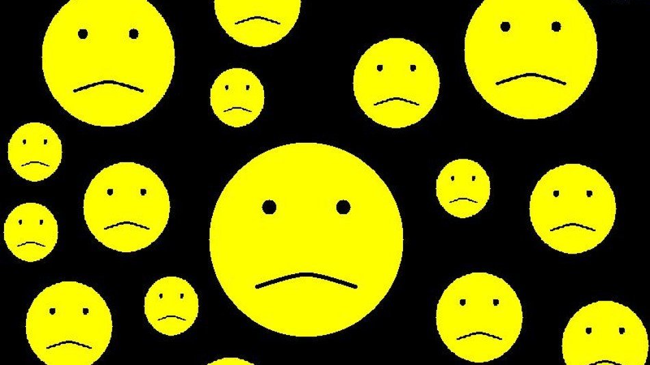 Sad smileys at black background