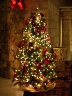 illuminated Christmas Tree at stone wall