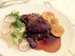 meat with a side dish on a white plate