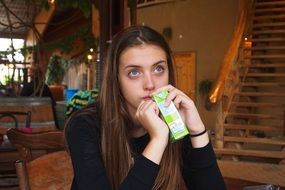 dreaming girl drinks juice out of the box