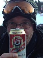 man in ski glasses with a can of beer in his hand