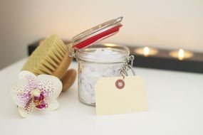 white body cream and scrub brush with a gift card