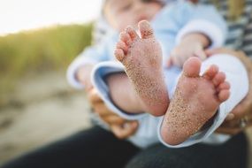 baby feet with sand on it