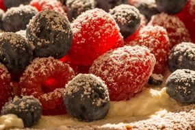 blueberries and rassberries on a cape with powdered sugar