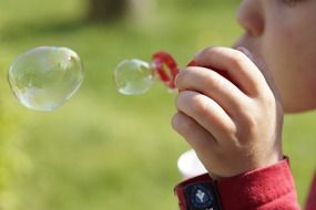 child making soap bubbles