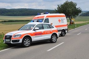 notary and ambulance cars parked on side of highway