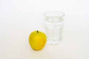 yellow apple and a glass of water