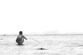 black and white photo of a boy fishing