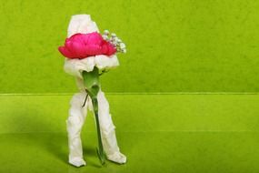 Paper man with rose on green background