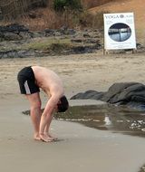 man practices yoga on the shore of the Arabian Sea, Karnataka, India