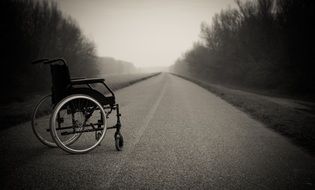 lonely wheelchair on the misty road