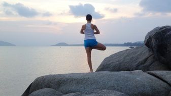 doing yoga on boulders on the Mediterranean