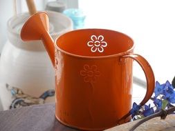 orange metal watering can