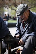 Man is cleaning shoes in the street