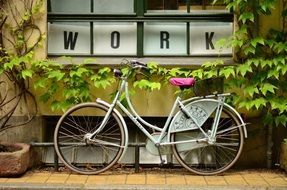 the bicycle is parked at the office wall