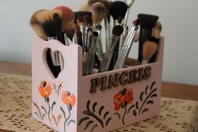 set of makeup brushes in a wooden stand
