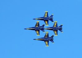 four blue fighters in the sky at an air show