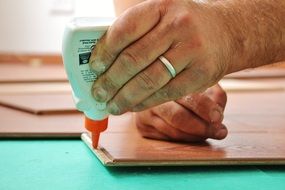 male hands apply glue to a tree