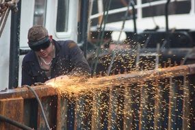 A man with a grinder on the ship