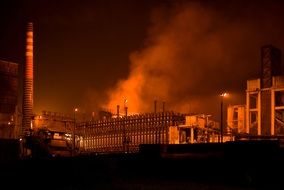 smoke over an industrial factory at night