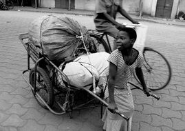 child pulls a cart with bags