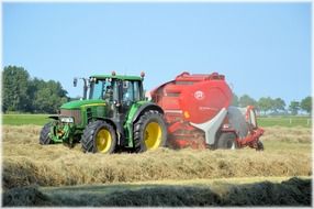 trailed tractor on crop field in countryside