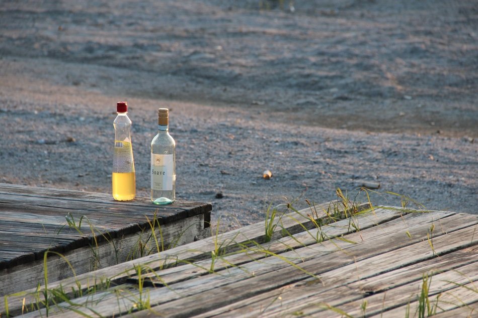 Still life with alcohol bottles near the water