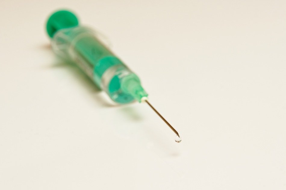 green syringe on white table