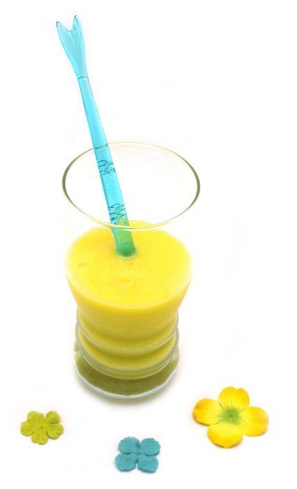 yellow juice in the glass with a straw