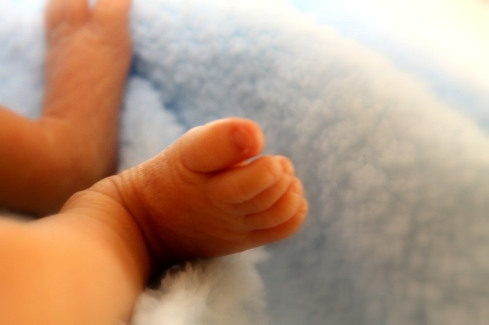 newborn's feet on soft tissue