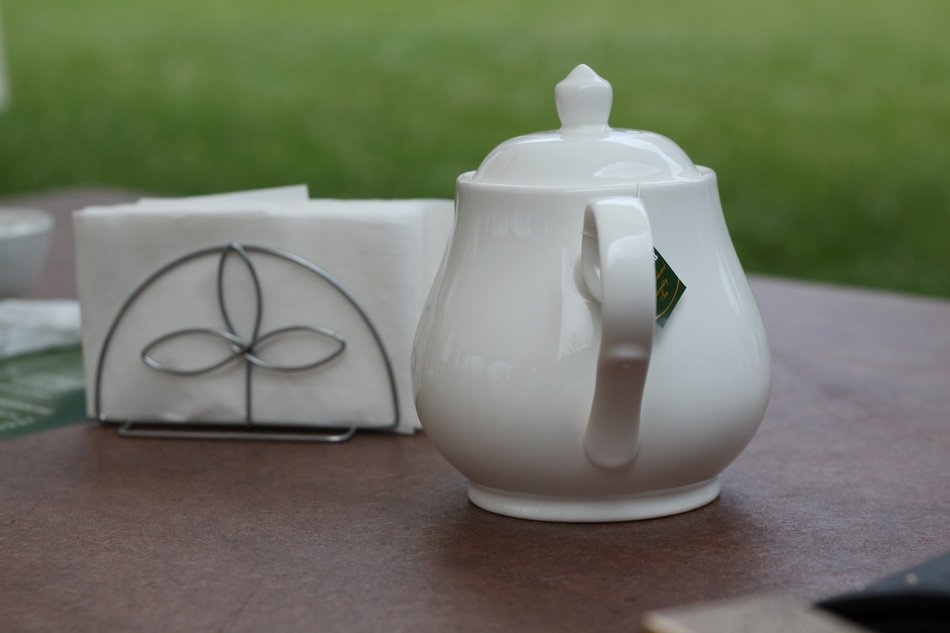 tea in a white teapot on a table in the garden