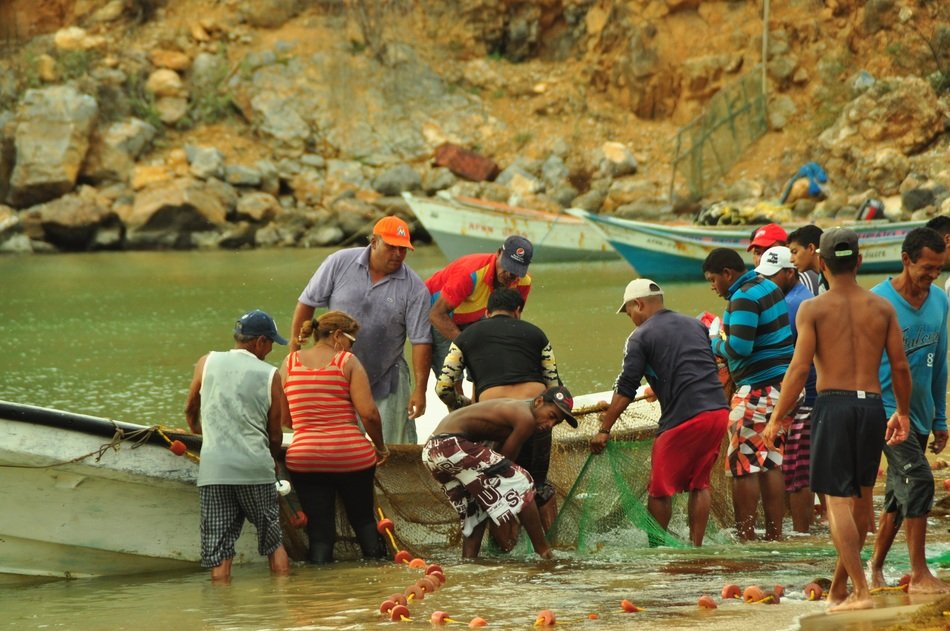 many fishermen near the boat on the shore