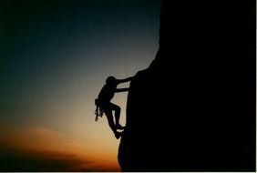 Muscular Rock Climber at the sunset