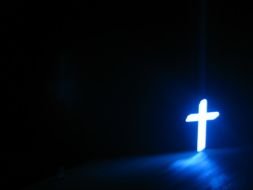 shining Christian Cross in darkness