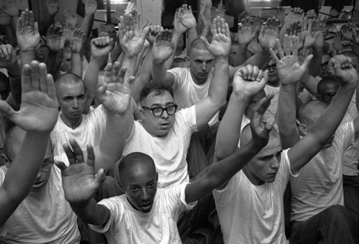 black and white photo of men with hands up