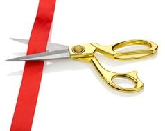 scissors with golden handles near the red ribbon