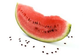 watermelon slice with seeds on a white surface